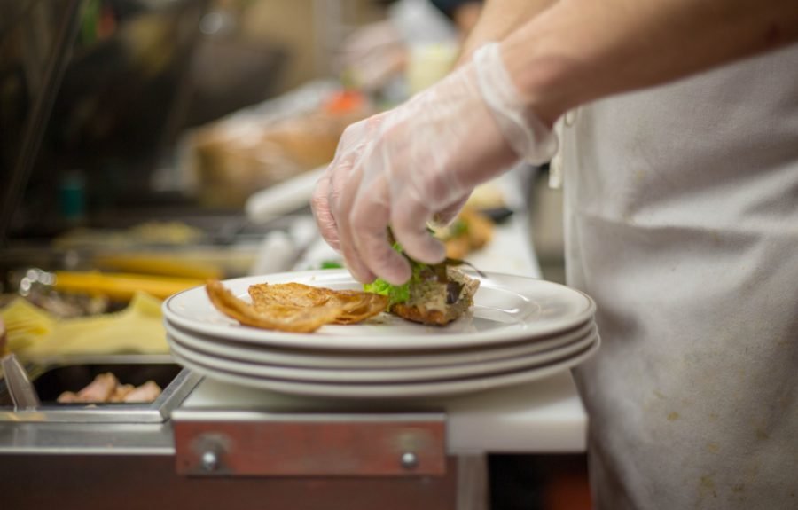 A chef in whites plating a dish in a professional kitchen